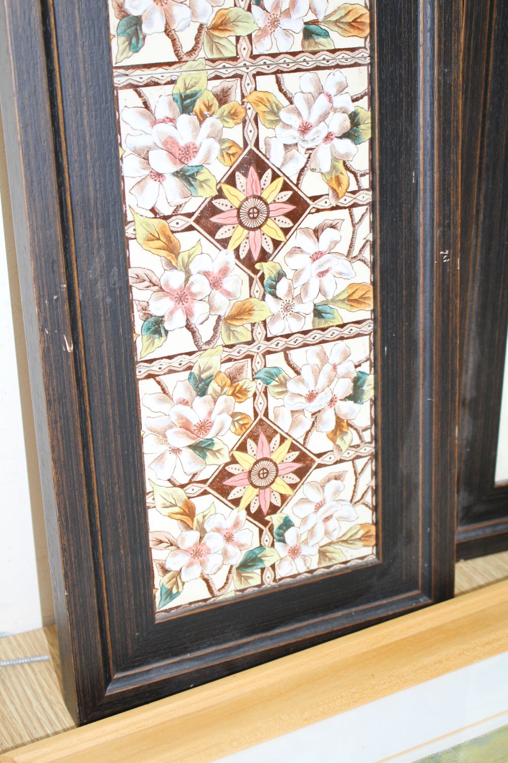 A pair of Victorian apple blossom tile panels and a set of six Art Nouveau foliate design tiles, all framed